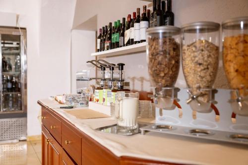 a counter with two vases filled with food at Hotel Posta in Comano Terme