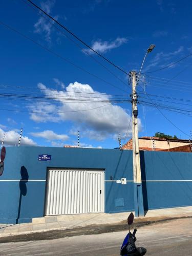 a motorcycle parked next to a blue building with a door at É De Casa Unidade 03 in Juazeiro do Norte