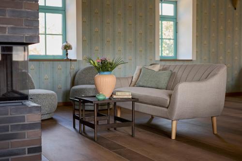 a living room with a couch and a vase on a table at Icce Borbirtok - Wine, Dine & Rest in Monoszló