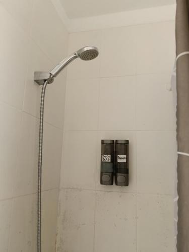 a shower in a bathroom with two bottles on the wall at Hostel Banana Surf House in Los Cristianos