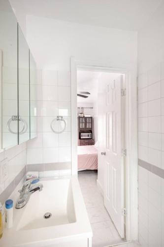 a white bathroom with a sink and a mirror at Brand new studio apartment in Vero Beach
