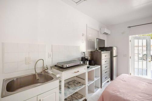 a small white kitchen with a sink and a sink at Brand new studio apartment in Vero Beach