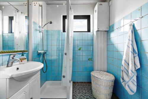 a blue tiled bathroom with a sink and a shower at 3076-Stege-Rusen-16 in Stege