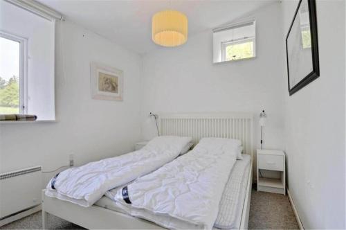 a white bedroom with a bed with white sheets at 4304-Borre-Klintevej-273 in Borre
