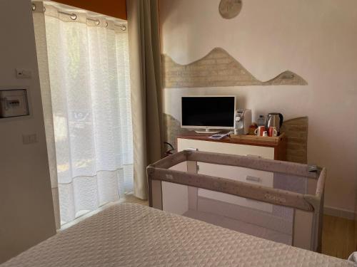 a bedroom with a bed and a desk with a television at Le Pervinche Affittacamere in Bastia Umbra