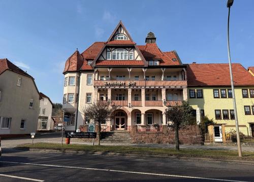 a large building with a red roof on a street at Hotel Deutsche Hof in Georgenthal