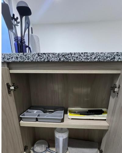 a cupboard with plates and utensils on it at Moderno Apartamento para 6 cerca de la Universidad Autónoma in Manizales