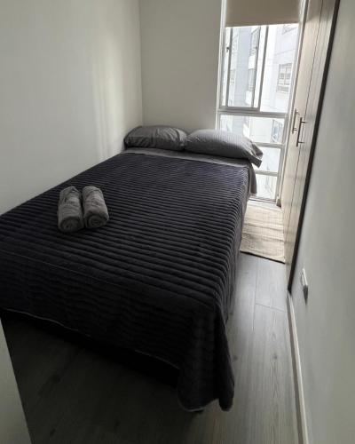 a bed with a pair of shoes on it in a room at Moderno Apartamento para 6 cerca de la Universidad Autónoma in Manizales