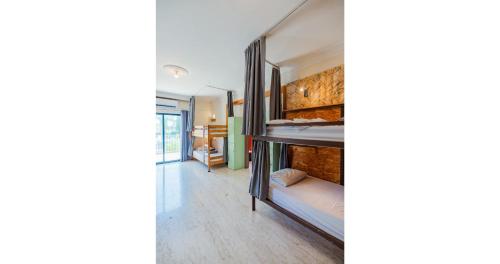 a room with a bunk bed and a hallway at House of Nissus Hostel in Ayia Napa