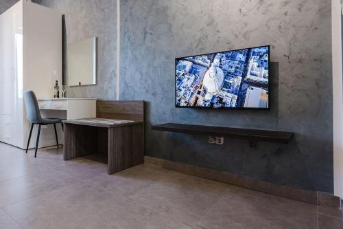 a room with a desk and a television on a wall at Central Apartment in St Julians in St Julian's