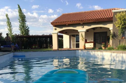 a swimming pool in front of a house at CASA DE CAMPO barrio privado Salta in Cerrillos