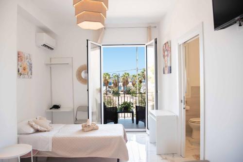 a room with two beds and a view of a balcony at Azzurro Mare in Isola delle Femmine