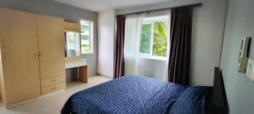 a bedroom with a blue bed and a window at Supalai Park Phuket City 2 bedrooms for rent in Phuket