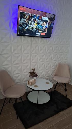 a room with two chairs and a table and a tv at McShane Studio 1 in Dudu