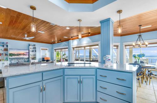 a kitchen with blue cabinets and a dining room at Sunrise Shores in Carrabelle