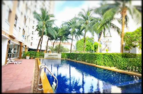 a swimming pool in front of a building with palm trees at Supalai Park Phuket City 2 bedrooms for rent in Phuket