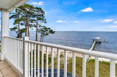 a balcony with a view of the water and a dock at Sunrise Shores in Carrabelle