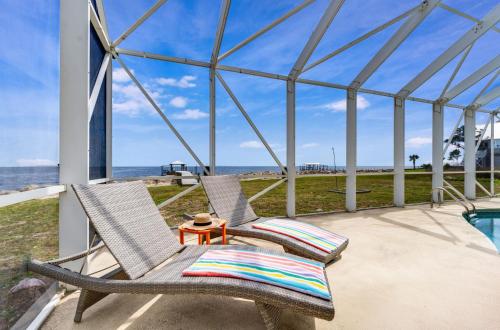 two chairs on a patio with a view of the ocean at Sunrise Shores in Carrabelle