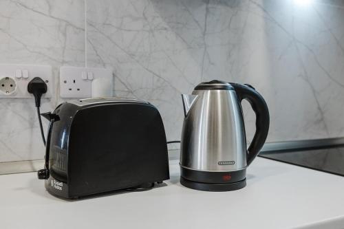 a tea kettle and toaster sitting on a counter at Central Apartment in St Julians in St Julian's