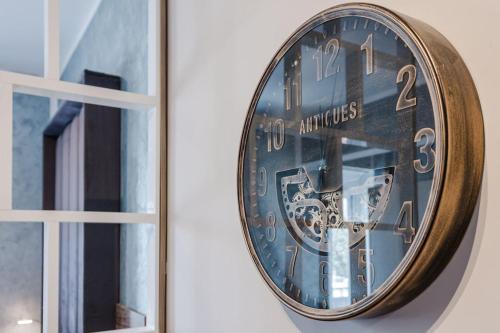 a clock hanging on a wall next to a window at Central Apartment in St Julians in St Julian's