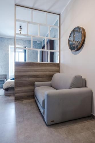 a couch in a living room with a clock on the wall at Central Apartment in St Julians in St Julian's