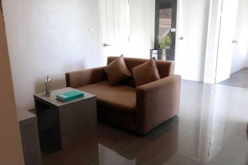 a living room with a couch and a coffee table at Dancenter Sukhumvit 107 Bangkok Hotel in Bangkok