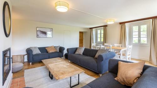 un salon avec des canapés bleus et une table dans l'établissement La Grande Maison Rouge, à Angoustrine