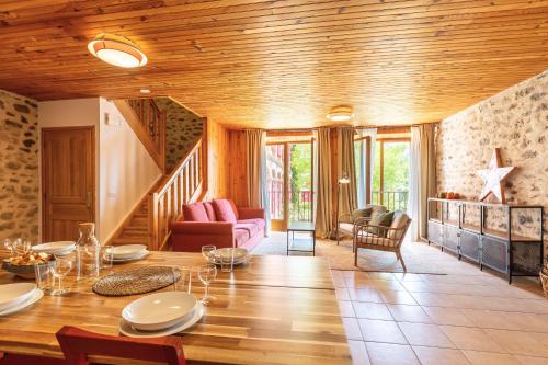 ein Wohnzimmer mit einer Holzdecke und einem Tisch in der Unterkunft La Grande Maison Rouge in Angoustrine