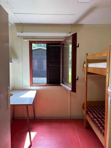 a small room with a bunk bed and a window at Kemp Chatky Nové Město in Náchod