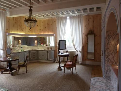 - un salon avec une table et un miroir dans l'établissement Hôtes de Montboulan, à Salbris