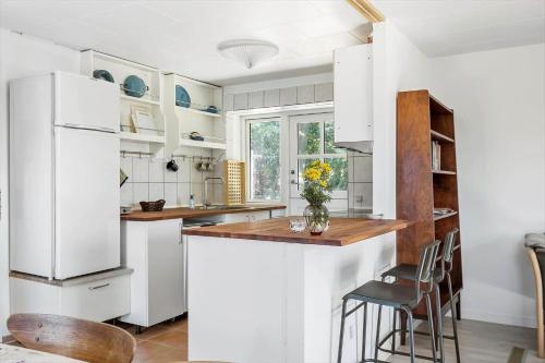 a kitchen with white appliances and a counter with chairs at 8217-Vordingborg-Kvaedevej-10 in Vordingborg