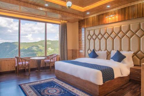 a bedroom with a large bed and a table and chairs at The Mountain Palace Kufri By Exotic Stays in Kūfrī