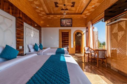a bedroom with two beds with blue pillows at The Mountain Palace Kufri By Exotic Stays in Kūfrī