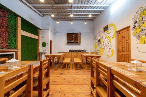 a dining room with wooden tables and benches at The Mountain Palace Kufri By Exotic Stays in Kūfrī