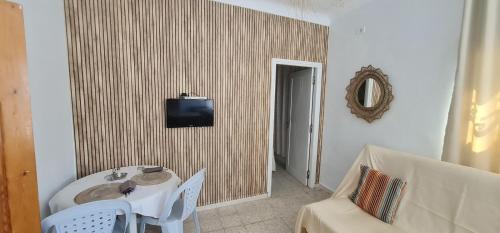 a room with a table and a tv on a wall at Appartement s1 hamamet in Hammamet