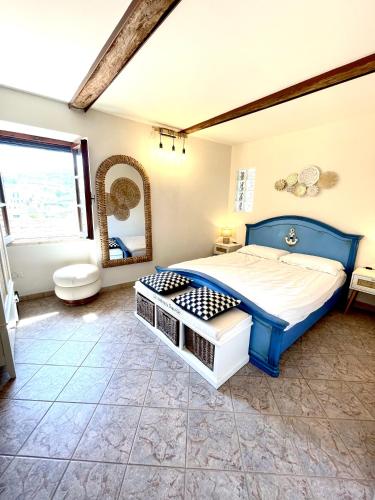 una camera da letto con un letto blu e uno specchio di bilocale in centro a capoliveri a Capoliveri