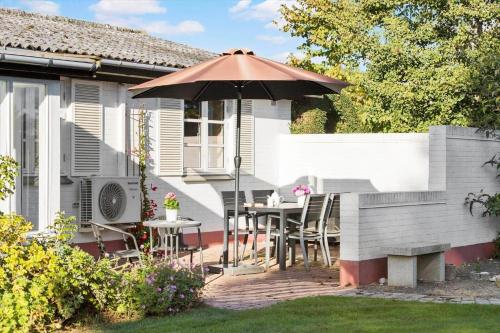 a patio with a table and an umbrella at R728-Rodvig-Peder-Minesvej-4 in Rødvig