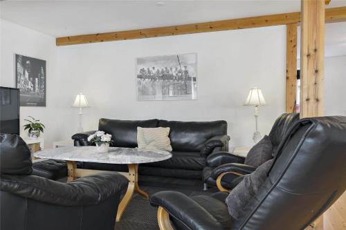 a living room with black leather furniture and a table at 8002-Kalvehave-Sondre-Led-4 in Kalvehave