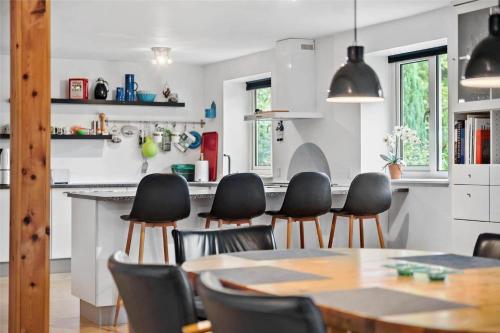a kitchen with a table and chairs and a counter at 8002-Kalvehave-Sondre-Led-4 in Kalvehave