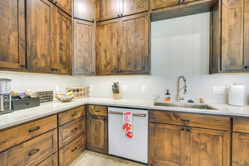 a kitchen with wooden cabinets and a white dishwasher at Lake Wapogasset Home with Dock 7 Mi to Amery in Amery