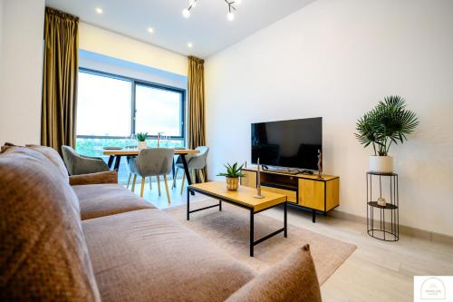 a living room with a couch and a tv and a table at YamaLuxe Luxury Apartments - București in Bucharest
