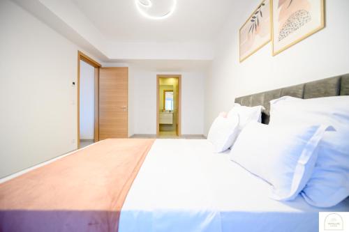 a bedroom with a large white bed with a wooden headboard at YamaLuxe Luxury Apartments - București in Bucharest
