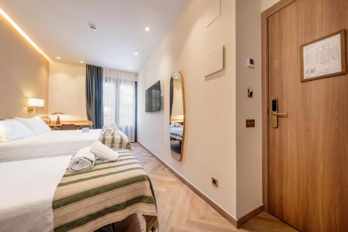 a hotel room with a bed and a mirror at Hostal Ambos Mundos in Barcelona