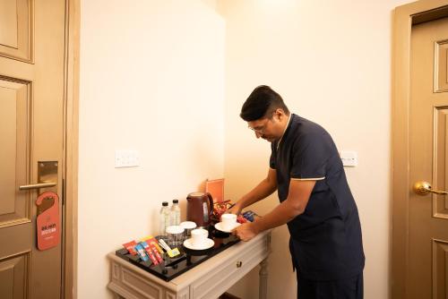 un hombre de pie en una cocina preparando comida en Cityscape Rooms & Suites, en Islamabad