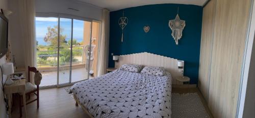Un dormitorio con una cama y una pared azul. en F2 vue mer dans résidence avec piscine, en Ajaccio