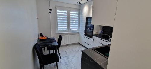 a kitchen with a table and chairs and a window at Korsako apartamentai in Šiauliai