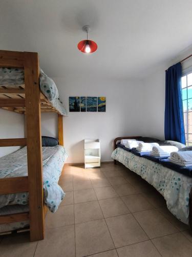 a bedroom with two bunk beds and a window at Cabañas Willy Azul con pileta climatizada y parque en Mendoza in Las Compuertas