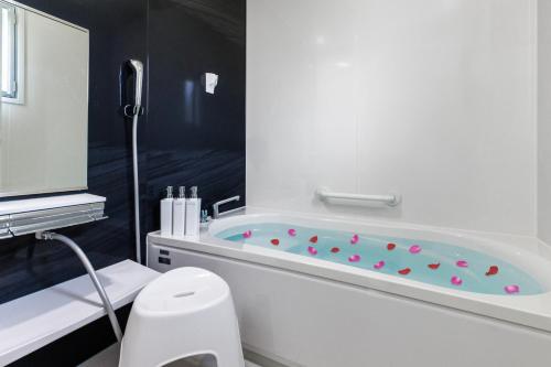 a bathroom with a tub with pink balls in it at 沖縄うるま市 最大9名OK BBQ 徒歩1分で天然ビーチ 広々3部屋の快適ステイ Villa Ohana in Uruma