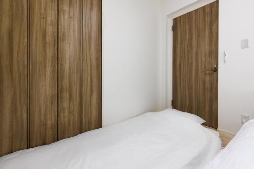 a bedroom with a wooden cabinet and a bed at 沖縄うるま市 最大9名OK BBQ 徒歩1分で天然ビーチ 広々3部屋の快適ステイ Villa Ohana in Uruma