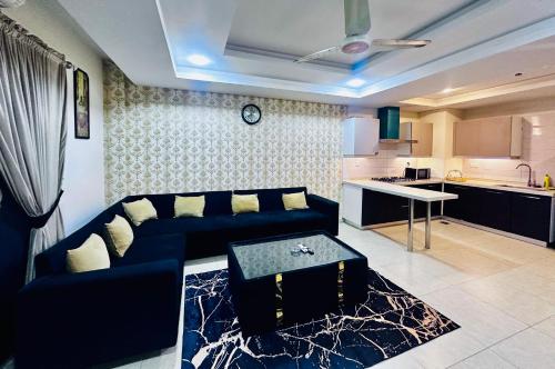 ラーワルピンディーにあるSunset Apartment Bahriaの青いソファとキッチンのあるリビングルーム